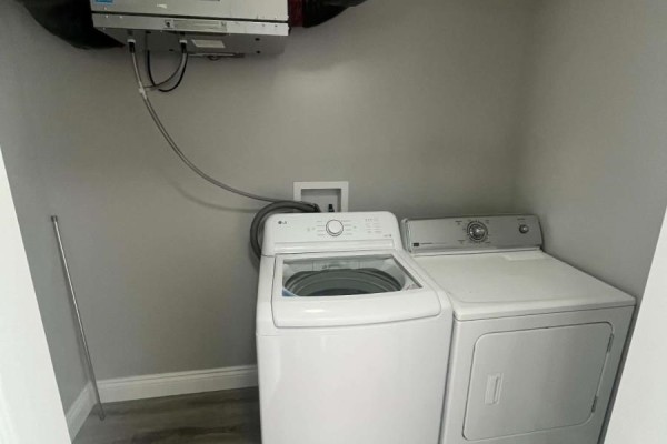 Laundry room with grey walls featuring a white top-load washer and a white dryer. - 3 Mcgregor Lane, Wabush