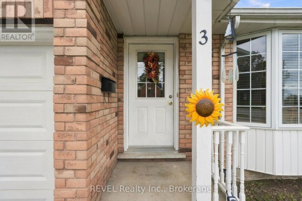 Close-up of the white front door with a glass insert and floral wreath. - 3 Ormond Street N, Thorold