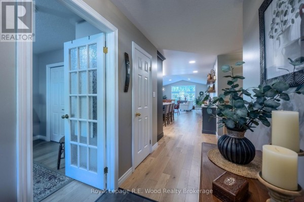 View down a hallway towards an open-concept living and dining area with a vaulted ceiling. - 3 Otterview Drive, Norwich