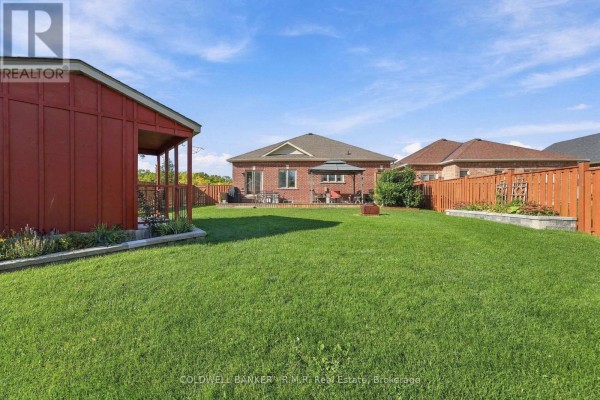 Expansive green backyard with a red shed and a brick house with a patio and gazebo. - 3 Pollock Avenue, Brock