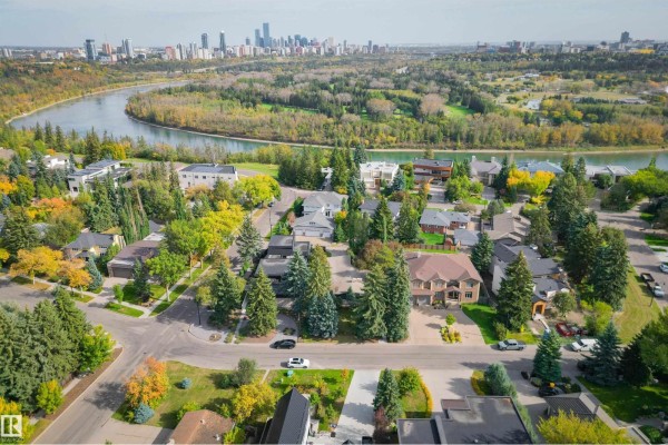 Aerial view of houses with a river and city skyline in the distance. - 3 Riverside Cr Nw, Edmonton