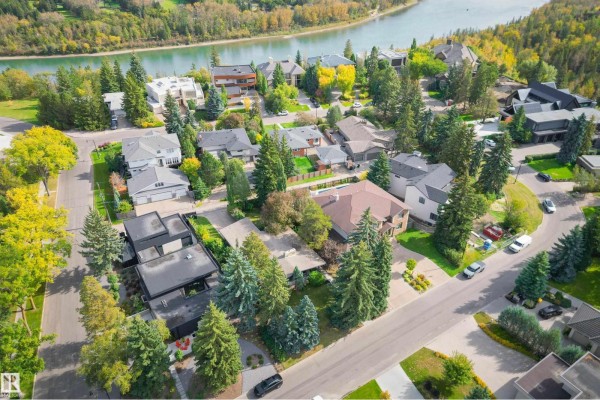 Aerial view of a tree-lined street with multi-story homes and a river. - 3 Riverside Cr Nw, Edmonton