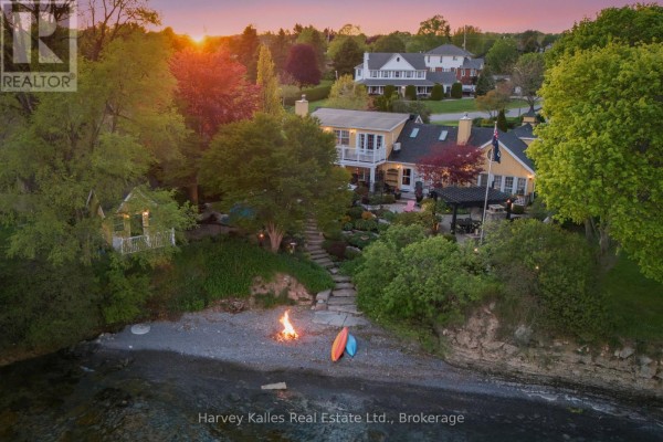 Aerial view of the property showing the house, backyard, and shoreline with a fire pit. - 3 Skiff Cove Place, Prince Edward County