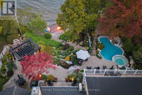 Overhead view of the backyard oasis with a freeform pool, spa, multi-level patio, and lake. - 3 Skiff Cove Place, Prince Edward County