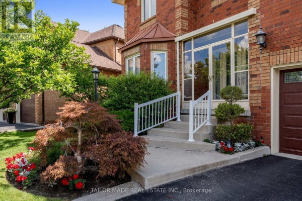 Close-up of the front entrance stairs with white railings and landscaping featuring a Japanese maple tree. - 3 Stonegate Drive, Brampton
