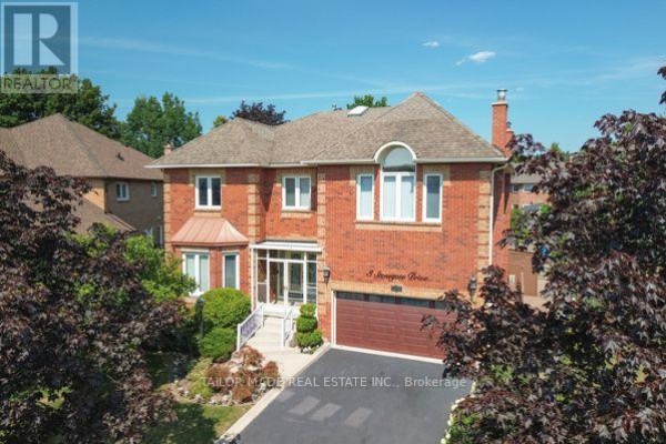 Aerial view of a red brick house with a peaked roof and surrounding trees on a sunny day. - 3 Stonegate Drive, Brampton