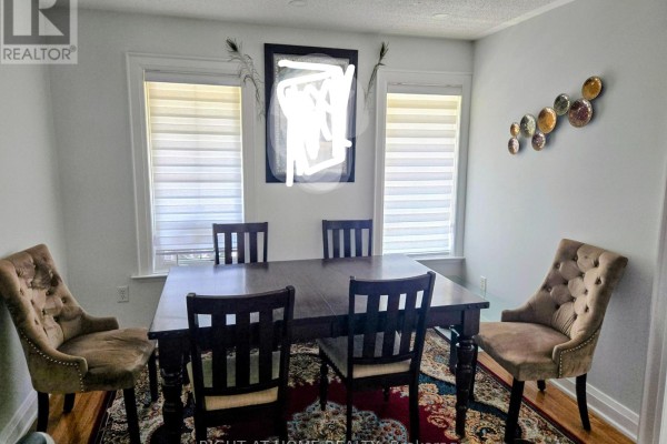 Dining room with a dark wood table, upholstered chairs, and window blinds. - 3 Wainwright Drive, Ajax