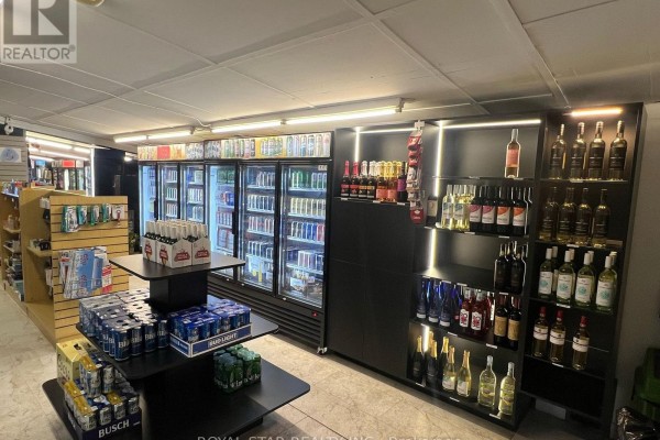 Interior view of a convenience store with refrigerators full of drinks, shelves stocked with wine, and various retail displays. - 3 West Street N, Norwich