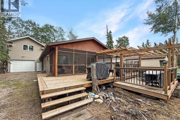 Exterior view of a white garage door and adjacent man door. - 3 White Spruce Crescent, Candle Lake