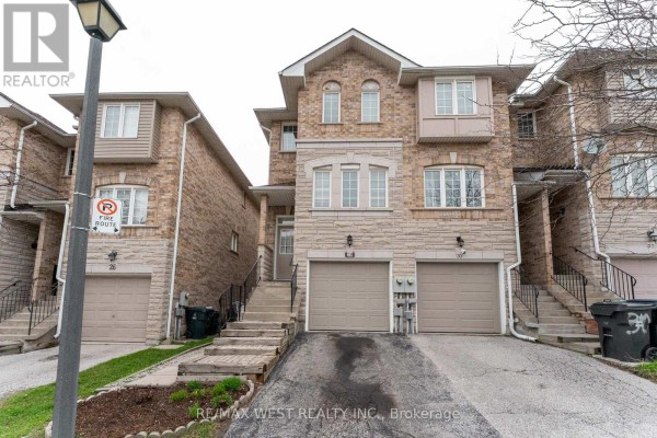 Front exterior view showing townhouses with stone accents, garages, and driveways. - 28 Shining Star Crescent, Toronto