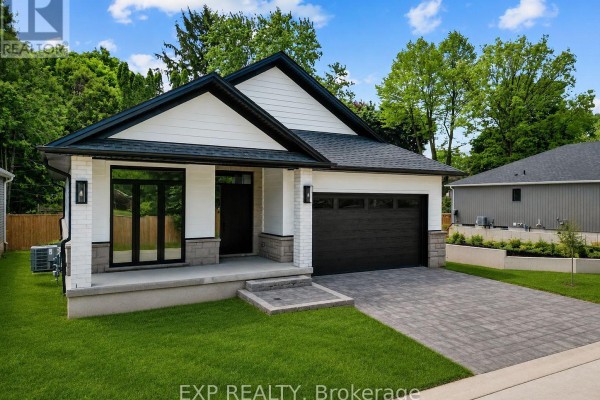 Front exterior view of a modern white and grey house with black garage door. - 30 - 430 Head Street N, Strathroy Caradoc