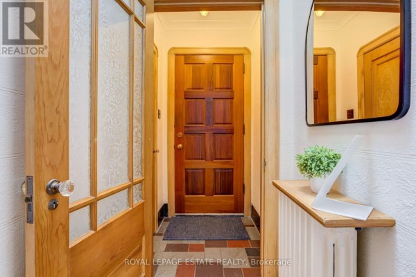 Interior entryway with a wooden front door, frosted glass side panels, and a mirrored wall. - 30 Barbara Crescent, Toronto