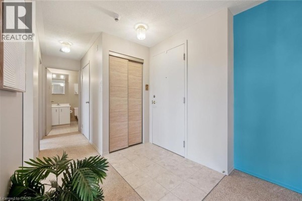 Interior hallway with a tiled floor, closet, and doorways to other rooms, including a bathroom. - 30 Blue Springs Drive Unit# 307, Waterloo