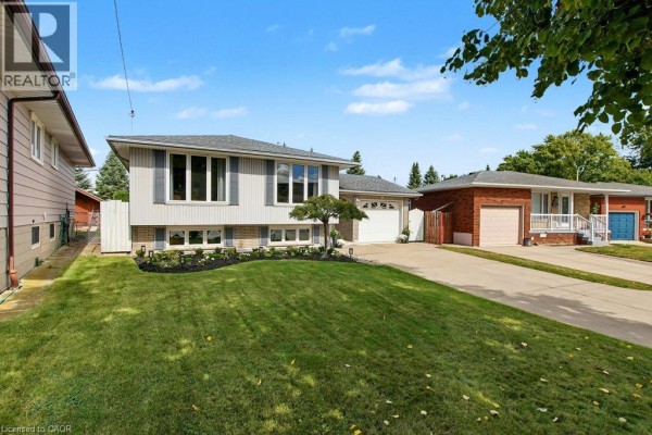 Side exterior view of the split-level house, showing adjacent properties and landscaping. - 30 Catalina Drive, Hamilton
