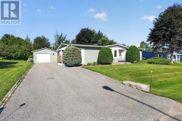 Side view of a light blue house with a driveway leading to a detached garage. - 30 Damsel Circle, Georgina