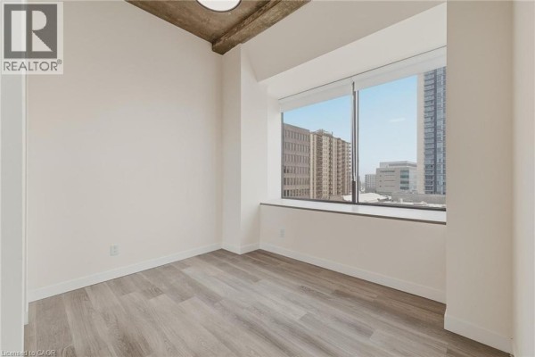 Kitchen featuring dark cabinetry, stainless steel appliances, and a view from the window. - 30 Duke Street W Unit# 315, Kitchener