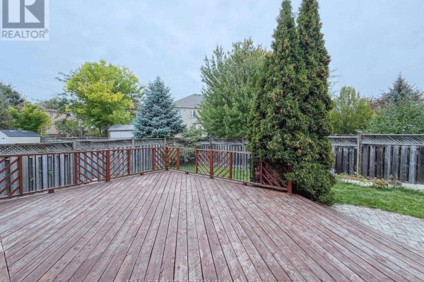 Wooden deck with a wooden railing and views of a backyard with trees. - 30 Emery Hill Boulevard, Markham