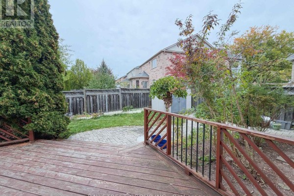 Wooden deck with a wooden railing overlooking a backyard with grass and trees. - 30 Emery Hill Boulevard, Markham