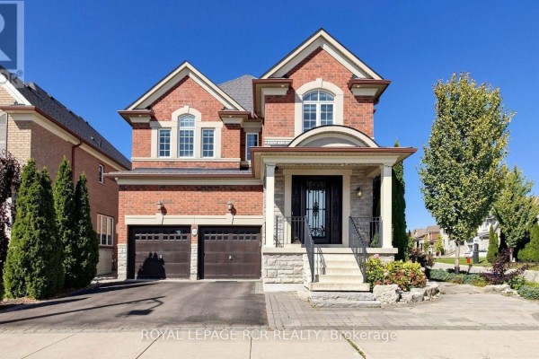 Front exterior of a red brick house with a covered entryway and two garage doors during the day. - 30 Fairmont Ridge Trail, King