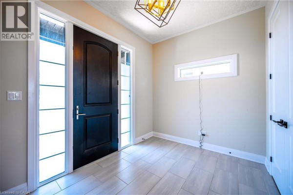 Interior entryway with a black front door, sidelight windows, and beige walls. - 30 Falconridge Drive Unit# Upper, Kitchener