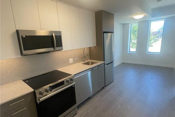 View of a modern kitchen with stainless steel appliances, light countertops, and light grey cabinetry. - 30 Francis Street S Unit# 207, Kitchener