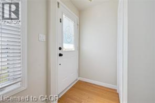 Interior view of the entryway showing a white door and hardwood floor. - 30 Kimberly Road Unit# Upper Unit, Cambridge