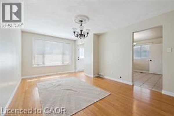 Living room with hardwood floors, a cream rug, and a chandelier. - 30 Kimberly Road Unit# Upper Unit, Cambridge