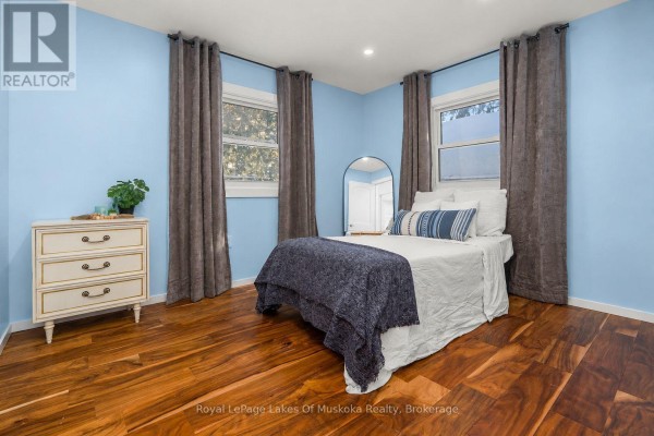 Bedroom with queen bed, white dresser, and hardwood floors - 30 Kitchen Road S Huntsville