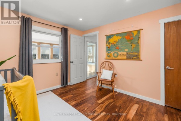 Bedroom with world map, wooden chair, crib, and hardwood floors - 30 Kitchen Road S Huntsville