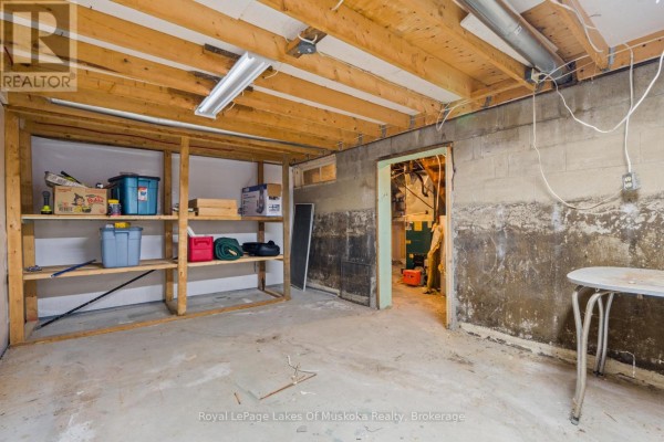 Basement with storage shelves, furnace, water heater, and exposed beams - 30 Kitchen Road S Huntsville