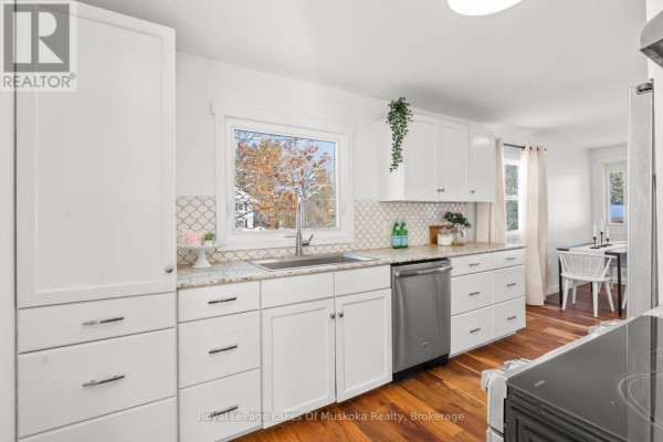 Modern kitchen with white cabinets, granite counters, and stainless steel dishwasher - 30 Kitchen Road S Huntsville