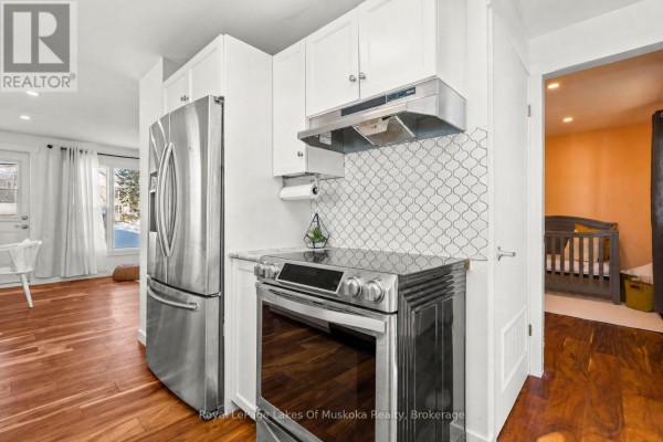 Stainless steel appliances, modern backsplash, and white cabinets in kitchen - 30 Kitchen Road S Huntsville