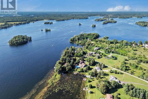 Aerial view of a waterfront property with several houses, trees, and a vast expanse of blue water. - 30 R14 Road, Rideau Lakes