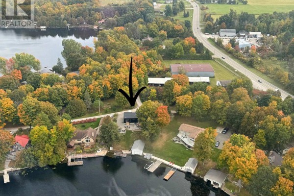 Aerial view of a residential property with a black house, surrounded by trees and waterfront. - 30 R7a Road, Rideau Lakes