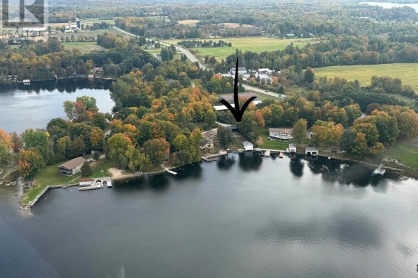 Aerial view showing multiple waterfront properties along a lake, with autumn foliage. - 30 R7a Road, Rideau Lakes