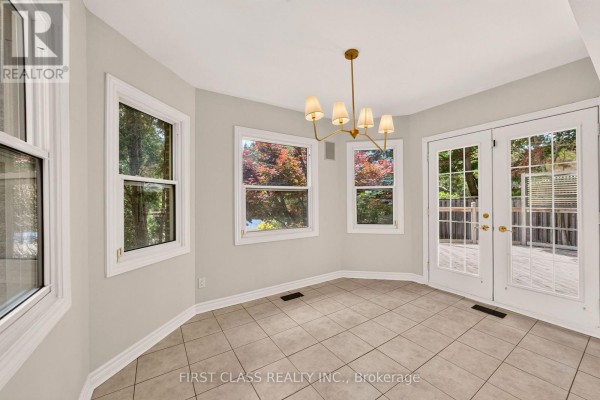 Dining room with tiled floor, modern chandelier, and glass doors - 30 Ritter Crescent Markham