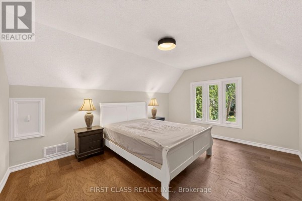Bedroom with white sleigh bed, hardwood floors, vaulted ceiling, and dormer windows - 30 Ritter Crescent Markham