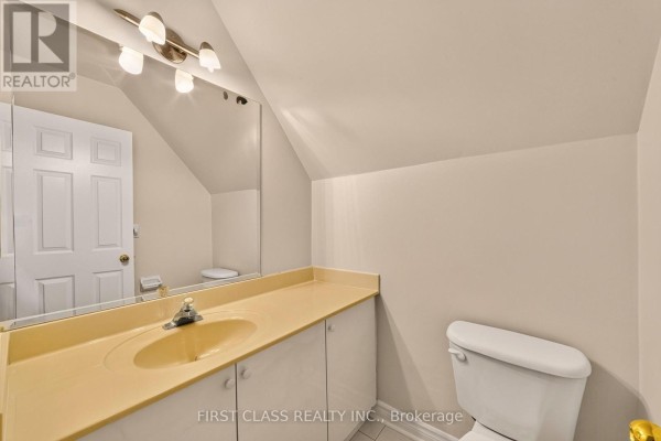 Beige vanity with sink, toilet, and door - 30 Ritter Crescent Markham