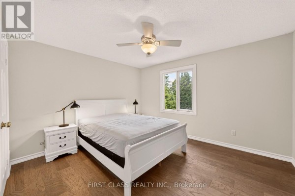 Bedroom with white sleigh bed, hardwood floors, and ceiling fan - 30 Ritter Crescent Markham