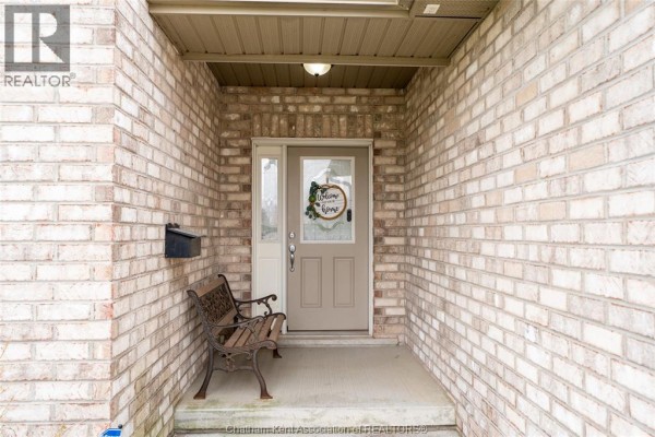 Front door with a wreath and a metal bench on the covered porch. - 30 St Michael Avenue, Chatham