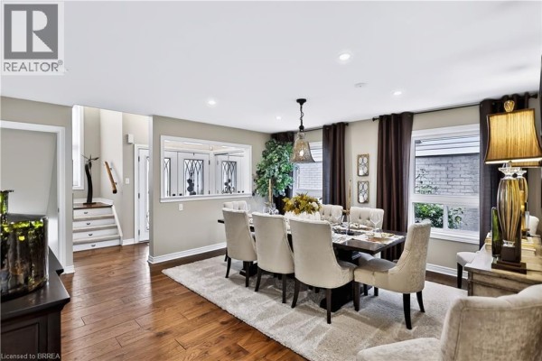 Dining room showing the table, chairs, and view into the foyer and hallway with stairs. - 30 Waldie Crescent, Brantford