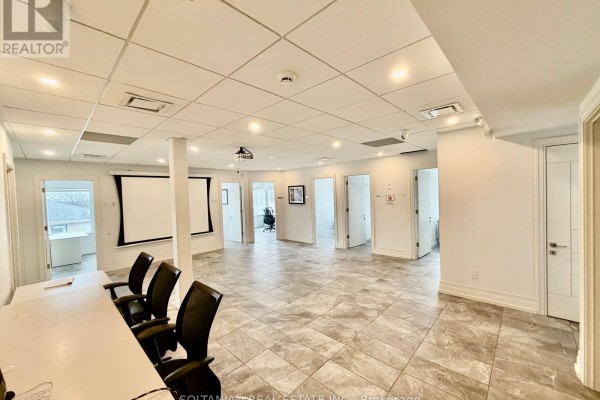 Wide view of office interior showing desks, chairs, and doorways. - 300 - 175 Willowdale Avenue, Toronto
