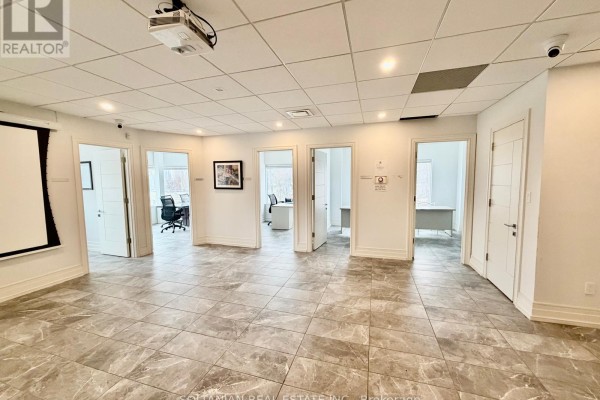 Office space with projector, screen, and several interior doors leading to rooms. - 300 - 175 Willowdale Avenue, Toronto