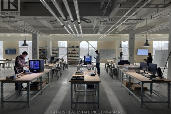 Workshop space with metal tables, 3D printers, computers, and people working. - 300 - 501 Alliance Avenue, Toronto