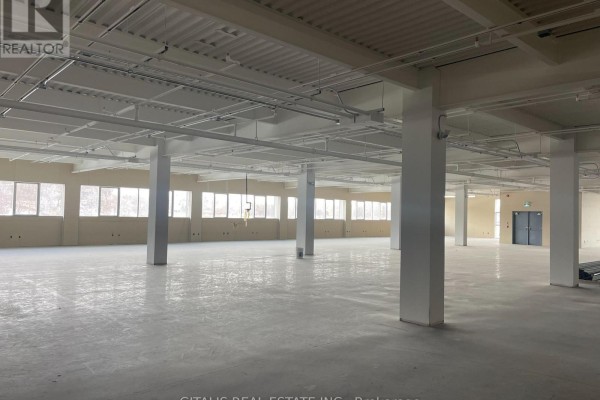 Large, unfinished commercial space with concrete floors, white columns, and many windows. - 300 - 501 Alliance Avenue, Toronto
