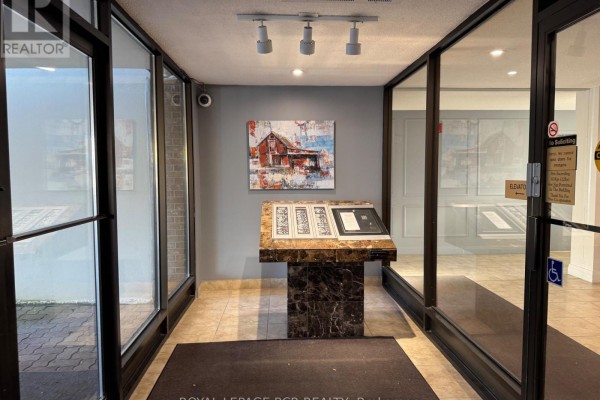 Apartment building lobby with glass doors, digital directory, and abstract barn painting. - 300 - 8 Fead Street, Orangeville