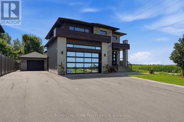 Side view of a modern house on Dore Street with a detached garage and stone exterior. - 300 Dore Street, The Nation