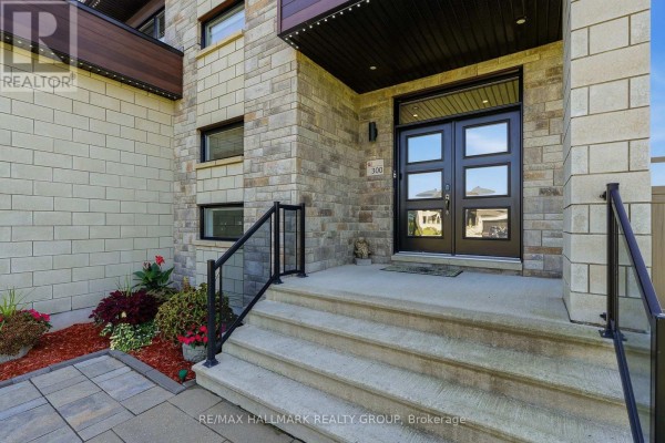 Close-up of the front entrance of a modern house with double doors, stone facade, and glass railings. - 300 Dore Street, The Nation