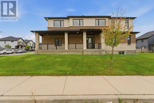 Front view of a townhouse with a covered porch, brick and beige facade, and windows. - 300 Ibanez Walk, Ottawa