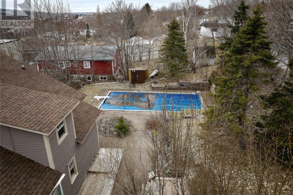 Similar view of the cleared area, showing the house in the background and snow around. - 300 Topsail Road, St  John S